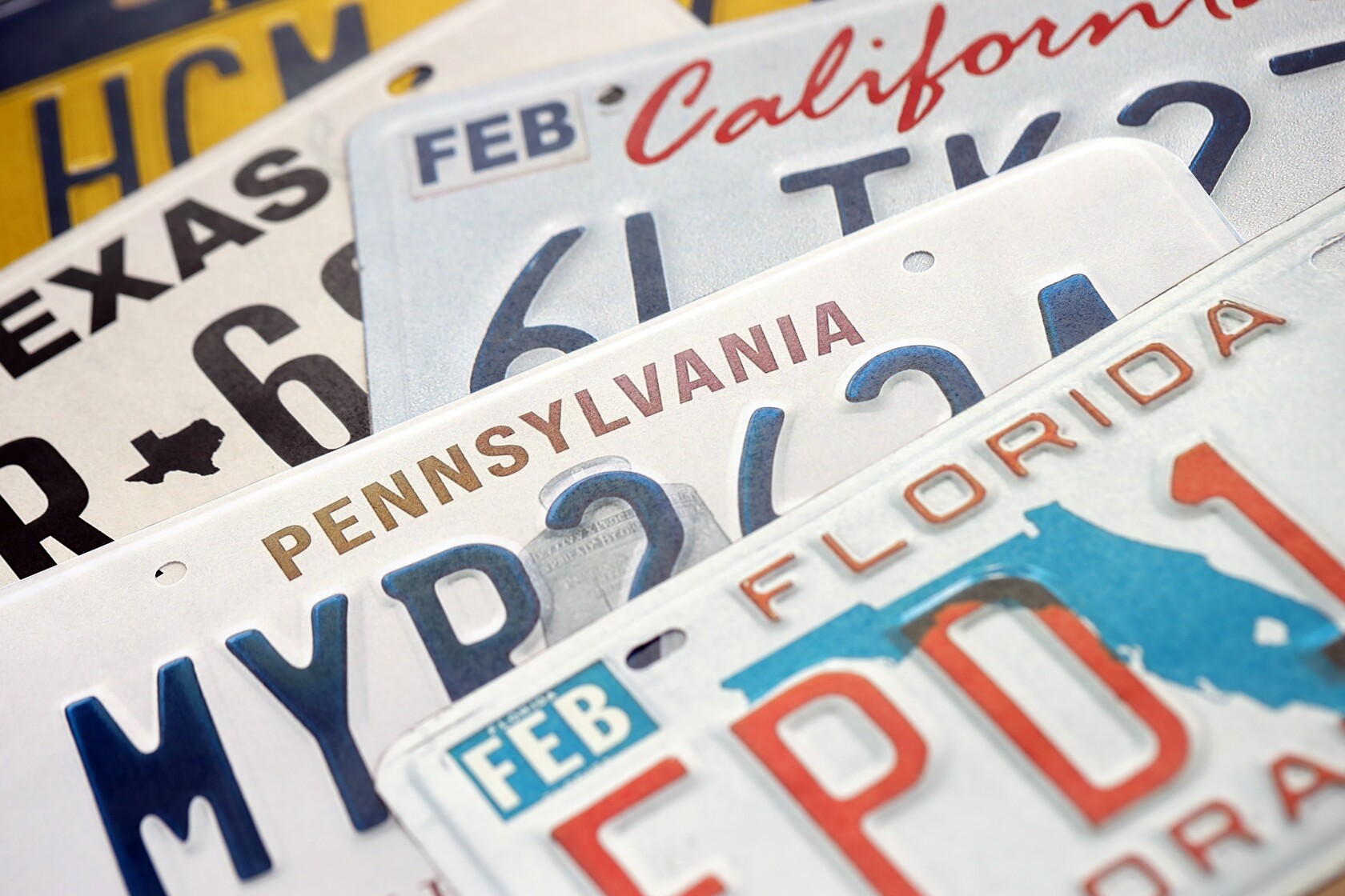 Collection of license plates from different states, representing vehicle registration requirements