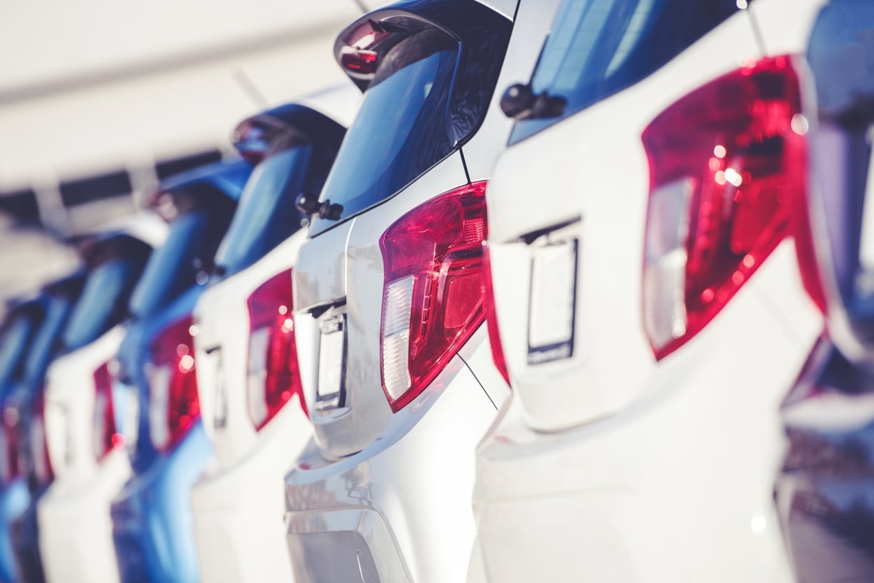 Row of new cars lined up at a dealership, representing New York vehicle registration renewal costs